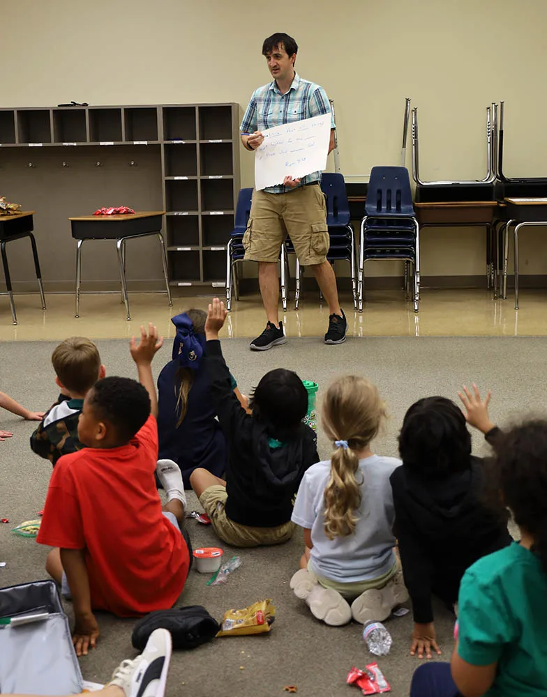 IMG_3127 A leader teaches children seated on the floor of a classroom.